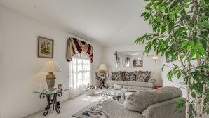 Ein Wohnzimmer mit einer Couch, einem Couchtisch, einer Lampe und dekorativen Accessoires.