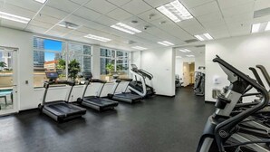 A gym with treadmills, exercise bikes, and a large window offering a city view. - 1BR Brickell High-Rise Condo - Balcony & Parking (Miami)