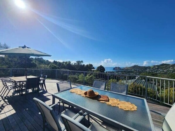 Une terrasse avec une table et des chaises, un parasol et une vue sur le paysage.
