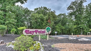 Schild für BayPoint mit Baum-Logo, umgeben von begrünten Flächen mit Steinen und Rindenmulch.