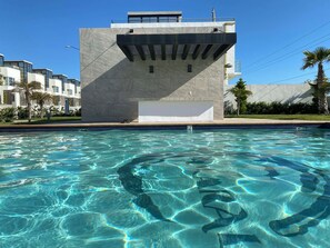 A modern building with a pool in front.