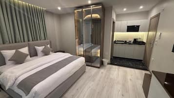 Deluxe dubbelrum - utsikt mot staden | VÀrdeförvaringsskÄp pÄ rummet, skrivbord och arbetsyta för laptop