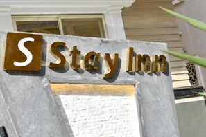 A Stay Inn sign with a large 'S' and the name 'Stay Inn' in metallic letters.