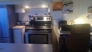 A compact kitchen with a stove, oven, and a coffee maker. - Spacious renovated 2 1/2 sleeps 3 (Montréal)