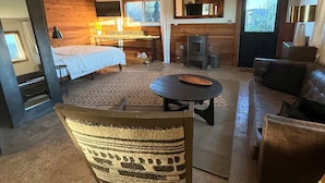 A modern living room with a bed, sofa, and a dining area. - Country Carriage House in Downtown Geyserville, Vineyard Views (Geyserville)