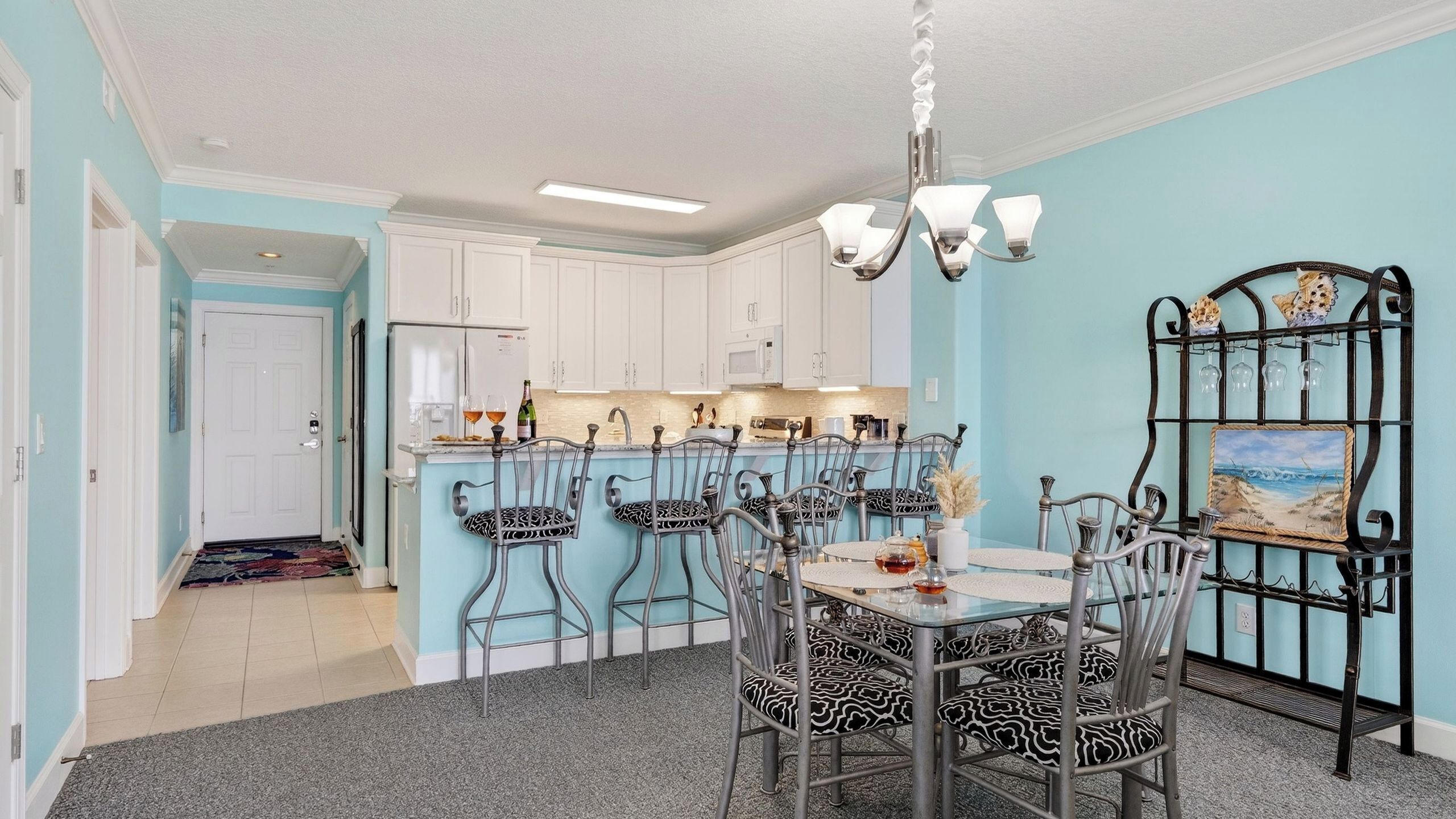 A dining area with a table set for four, surrounded by chairs with patterned cushions.