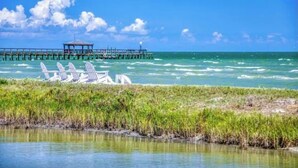 A pier extending into the ocean with a gazebo and lounge chairs along the shore. - BEACH THERAPY: Lovely Spacious and Comfortable Coastal Family Retreat (Rockport)