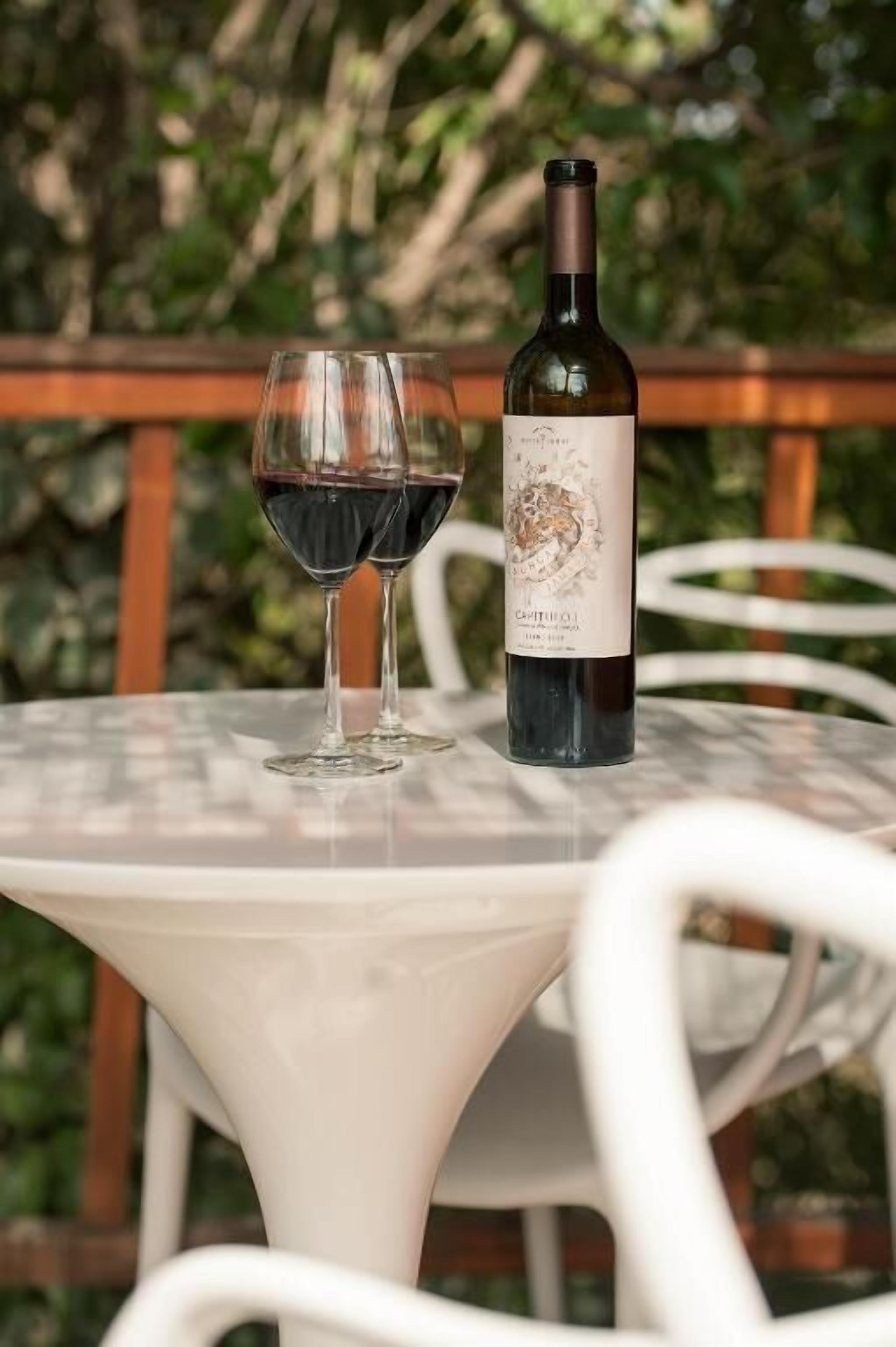 A table with a bottle of wine and two glasses on it.