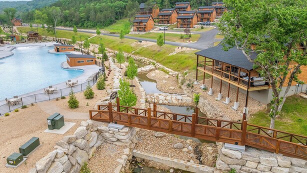 Ein Resort mit Pool, einer Holzbrücke und Gebäuden mit Balkonen.