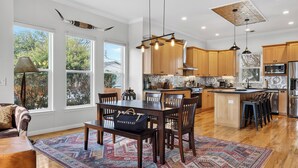 A spacious kitchen with wooden cabinets, a central island, and pendant lighting. - Chestnut Ember by Avantstay Indoor-outdoor Living + Firepit + Balcony + Near Downtown Austin Hotspots (Austin)