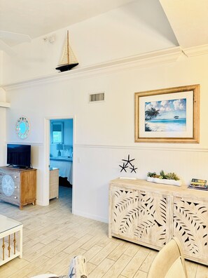 Una habitación con un armario de madera, un cuadro enmarcado, un televisor y una estrella decorativa.