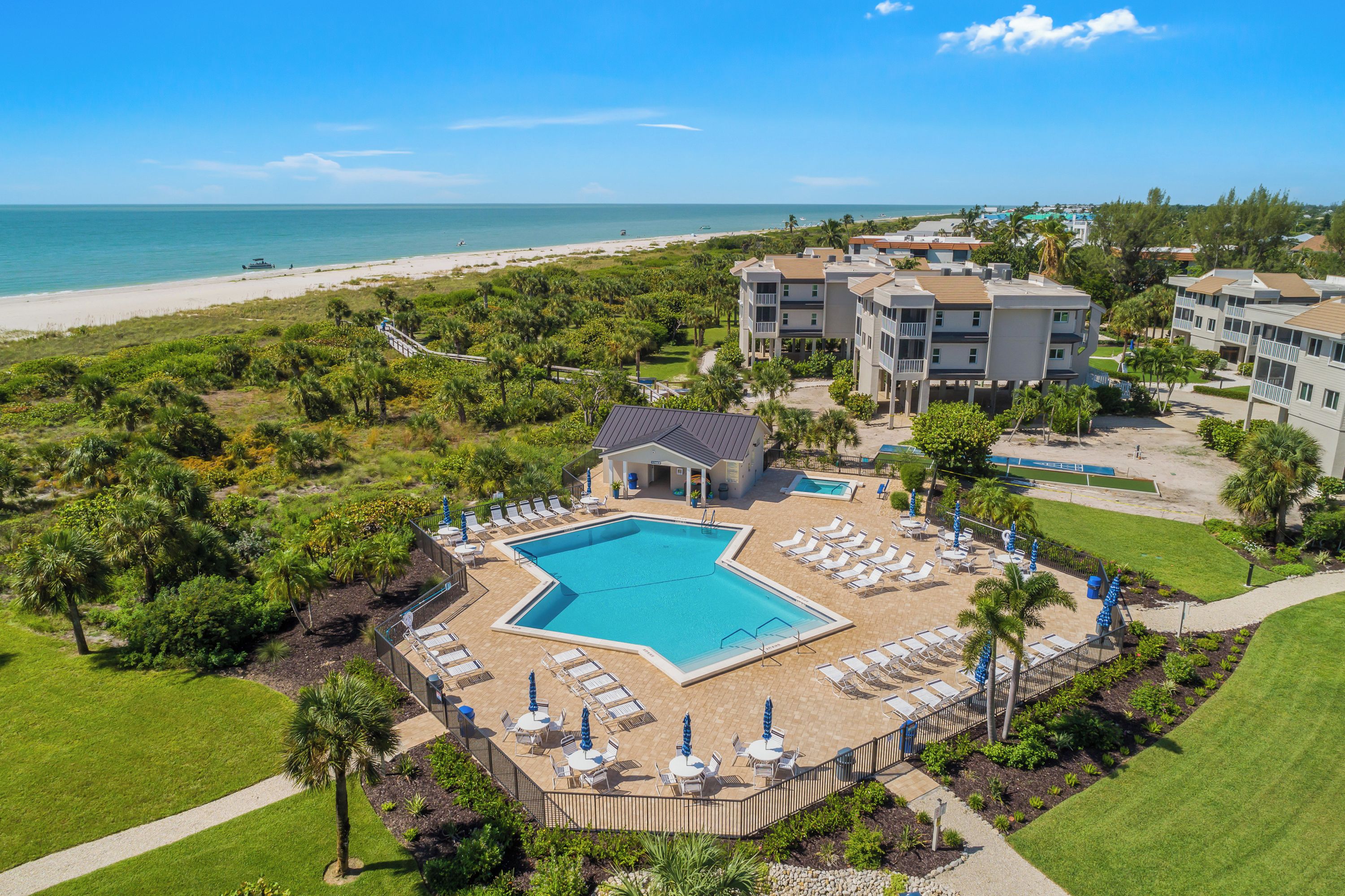 A resort with a swimming pool, beach access, and multiple buildings.