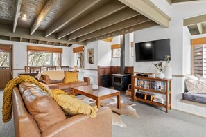 Ein geräumiges Wohnzimmer mit einer Ledersofa, einem Holztisch und einem Kamin.