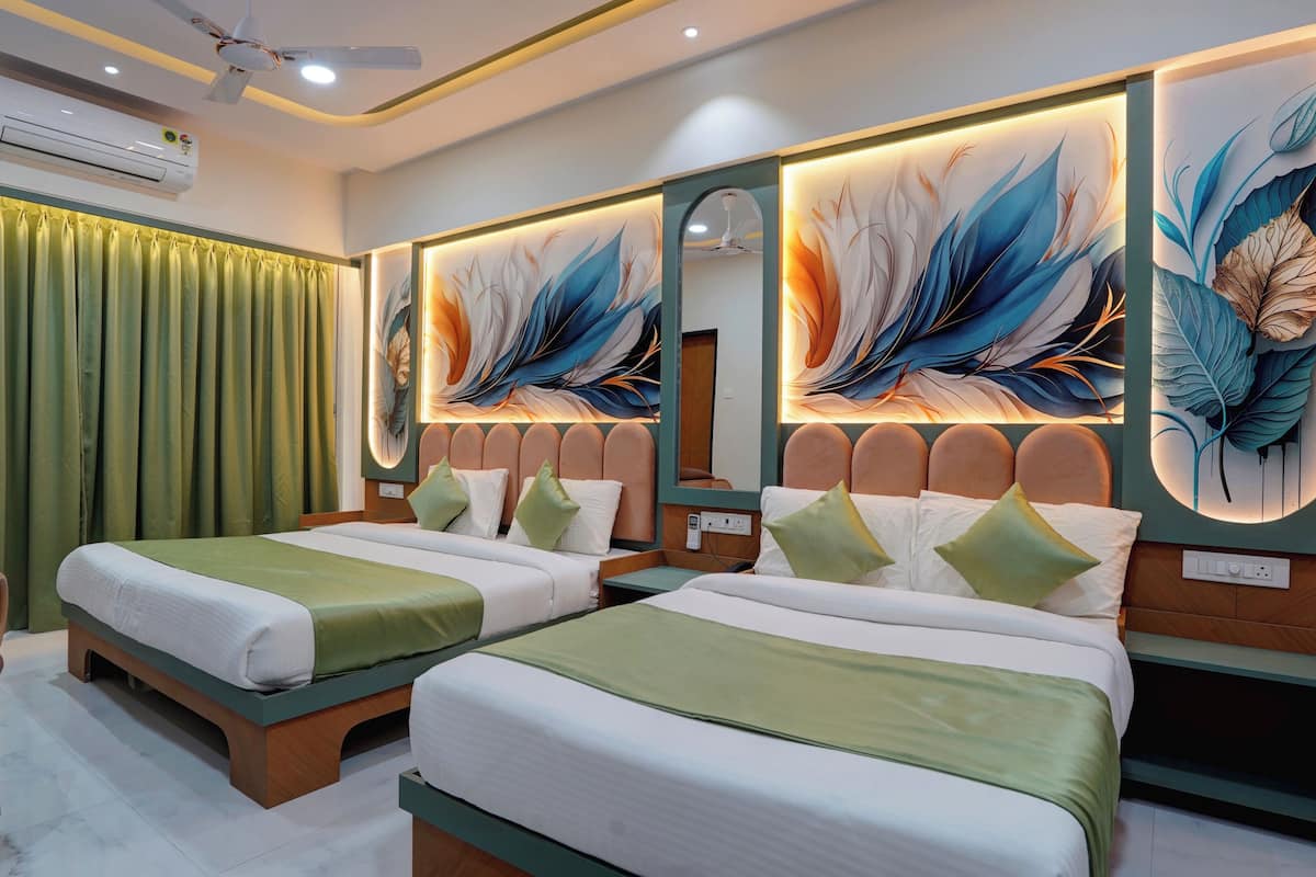 Habitación de hotel con dos camas, cortinas verdes, un ventilador de techo y aire acondicionado instalado en la pared.