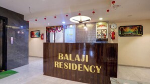 A reception desk with "BALAJI RESIDENCY" signage, a clock, and a fire extinguisher. - Hotel Balaji Residency Dombivli (Kalyan)