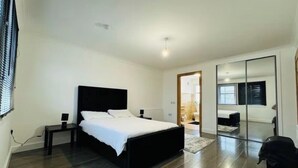 Una camera da letto moderna con un letto grande, un comodino, uno specchio e un armadio.
