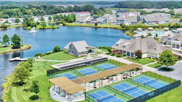 Et boligområde med en sø, tennisbaner og huse.