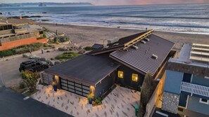 Una propiedad costera con garaje, entrada pavimentada y vistas a la playa y al océano.