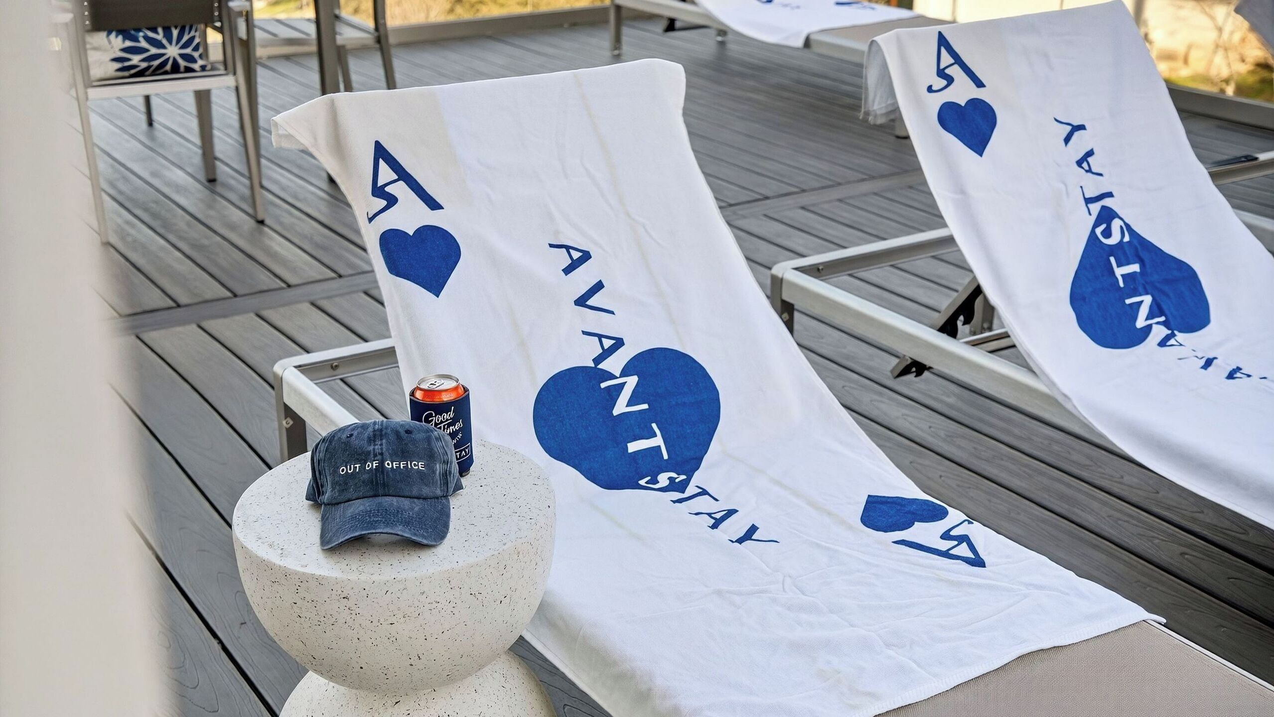 Una terraza con sillones de descanso, un sombrero y una lata sobre una mesa.