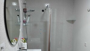 A modern bathroom with a white sink, mirror, and shower. - Penthouse with terrace (San Fernando)