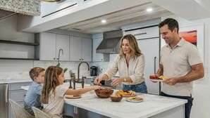 A modern kitchen with a central island, stainless steel appliances, and a large window. - Beachfront Bliss - Outdoor Pool - Sleeps 6 (Belleair Beach)