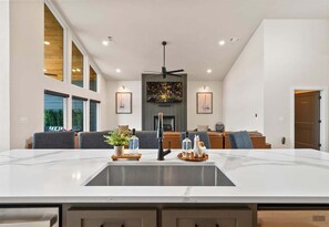 A modern kitchen with a large island, built-in appliances, and a dining area with seating. - Private Pool, Dock, Movie Room on Lake Hamilton (Hot Springs)