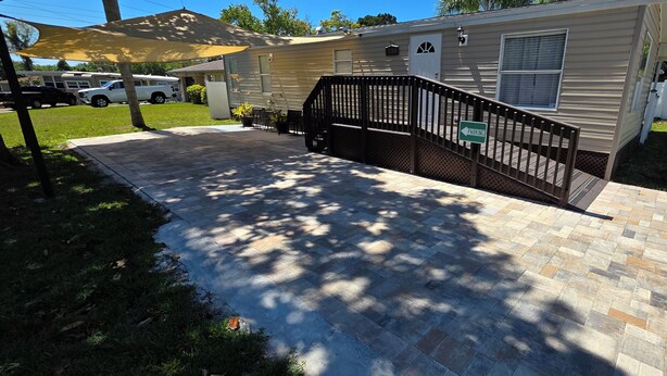 A mobile home with a paved driveway, a black metal fence, and a parking sign. - Lovely 3-bedroom mobile home with AC in charming Largo (Largo)