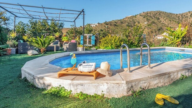 A swimming pool with a wooden deck, lounge chairs, and a sign reading "ruraldays". - Casa Luis Canillas de Aceituno by Ruralidays (Málaga)