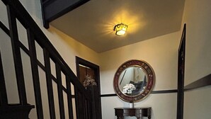 A staircase with black railings, a round mirror on a wall, and a small bench with shoes on the floor. - Peaceful 1-bedroom apartment with AC in vibrant Minneapolis (Minneapolis)