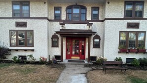 A large, two-story building with a red door and multiple windows. - Peaceful 1-bedroom apartment with AC in vibrant Minneapolis (Minneapolis)