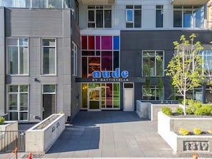 A modern building with a storefront named 'nude by Battistella'.