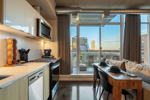 A modern kitchen with a built-in microwave, a wooden guitar, and a dining area with a table set for two.