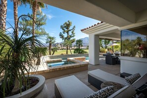 A patio with a pool, outdoor furniture, and a view of a golf course and mountains. - Casa Caliza at PGA West | Nicklaus Fairway Views (La Quinta)