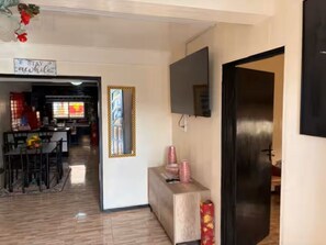 A hotel lobby with a dining area, a TV mounted on the wall, and a sign that reads "STAY AWAY". - 3-bedroom house in quaint Paramaribo with cool AC breeze. (Paramaribo)