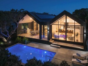 A modern house with a swimming pool, large glass windows, and a deck area. - Maison Noir | Heated Pool, Spa & Sauna (Sorrento)