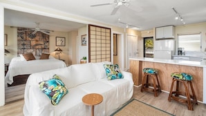 A compact hotel room with a bed, a sofa, a small dining area, and a kitchenette. - Kailua Village#604 (Kailua-Kona)