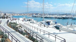 A marina with boats docked, a promenade with steps, and a cityscape in the background. - Charming apartment with balcony in the heart of Split (Split)