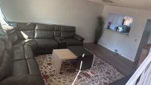Una sala de estar con un sofá modular, una mesa de centro y una alfombra estampada.