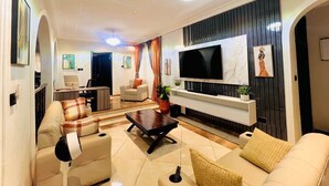 Una sala moderna con un televisor de pantalla plana grande, asientos cómodos y una chimenea.