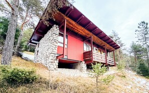 A cabin with a stone foundation, a red exterior, and a wooden balcony. - Panoramic Chalet in the ENI Village near Cortina D'Ampezzo - Spa - Restaurant (Corte)