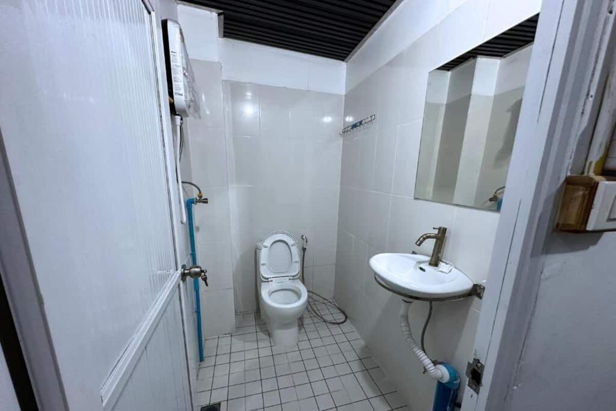 Un baño pequeño con inodoro, lavamanos y espejo.