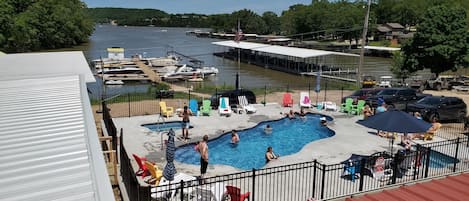 A swimming pool area with lounge chairs and a view of the water.