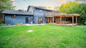 Une maison à deux étages dotée d’un patio couvert.