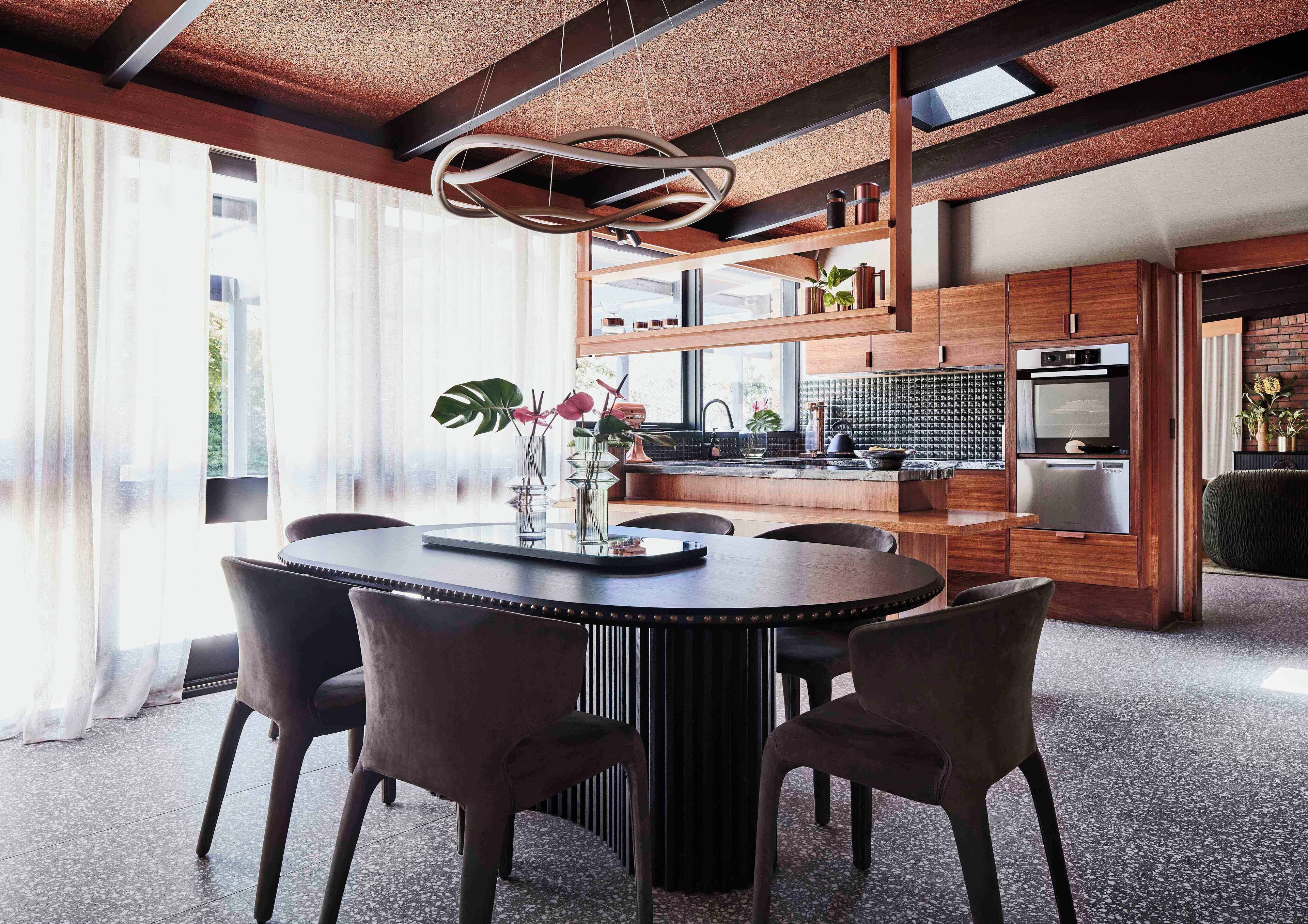 A modern kitchen with wooden cabinets, a stainless steel oven, and a black countertop.