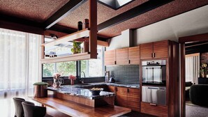 Una cocina moderna con armarios de madera, encimera de mármol y electrodomésticos de acero inoxidable.
