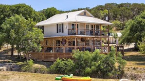 A two-story house with a balcony, surrounded by trees and a clear sky. - Paradise Canyon (Ingram)