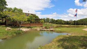 A pond with a wooden deck and a house in the background. - Paradise Canyon (Ingram)