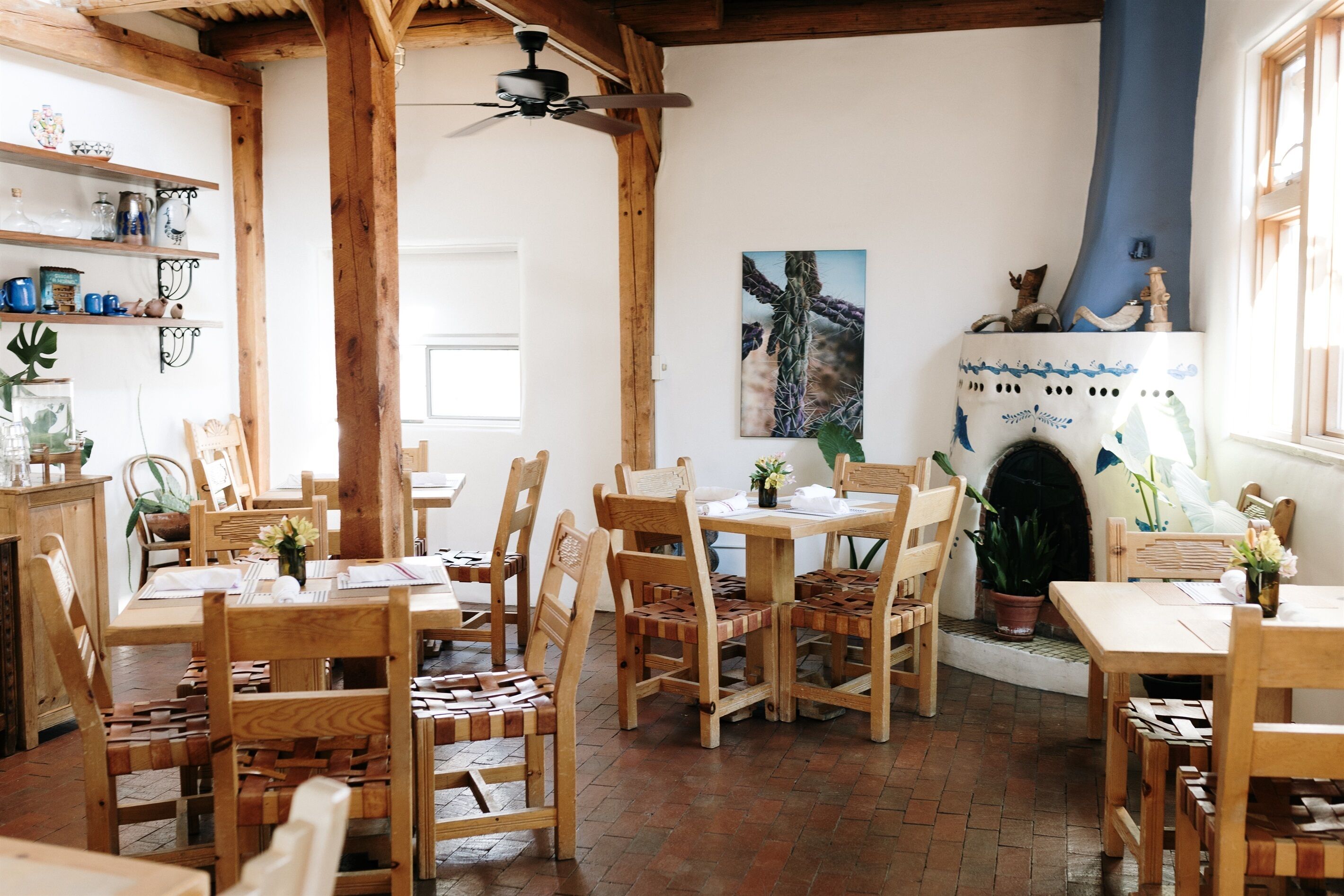A rustic dining area with wooden furniture and a brick floor.