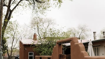A rustic building with a gravel driveway and a wooden door.