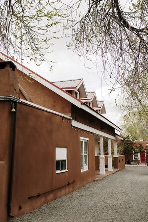 Un edificio con fachada marrón, ventanas blancas y techo rojo.